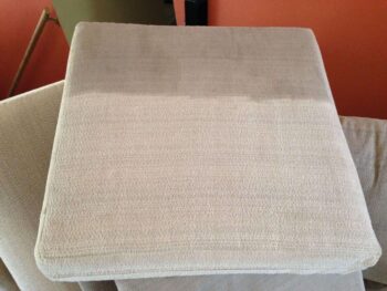 A couch cushion being cleaned